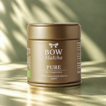 Goldene BOW Matcha PURE Dose im Licht vor salbeigrünem Hintergrund